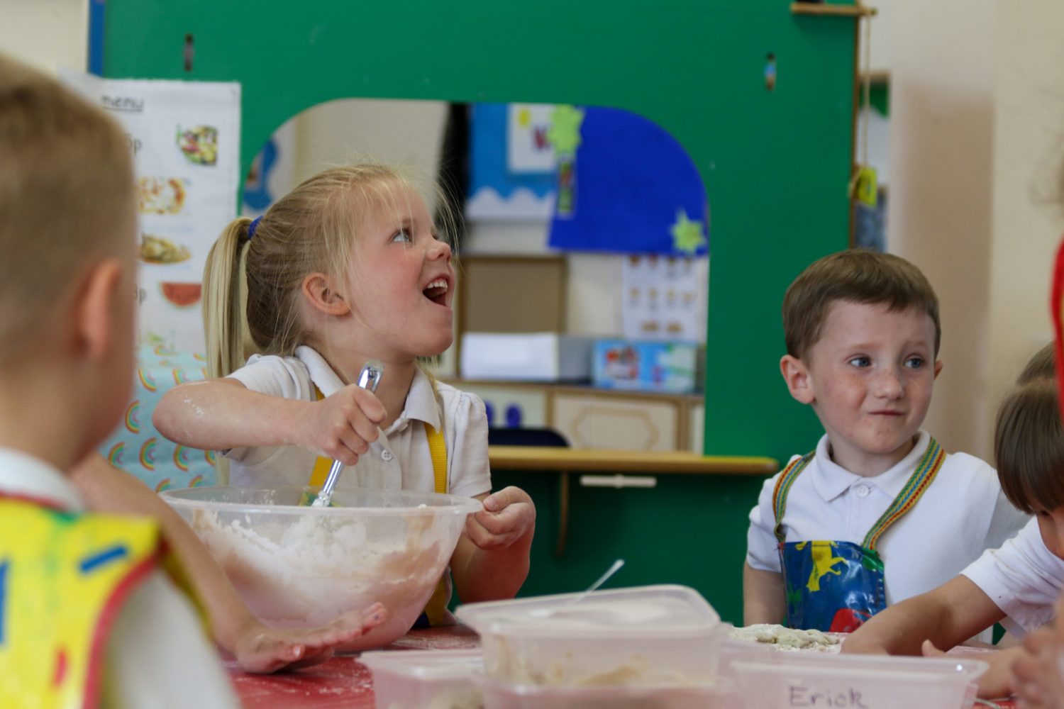 Two students engaging in messy play together in a cookery class.